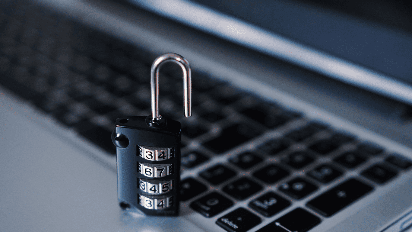 Combination padlock placed on a laptop keyboard symbolizing cybersecurity and data protection