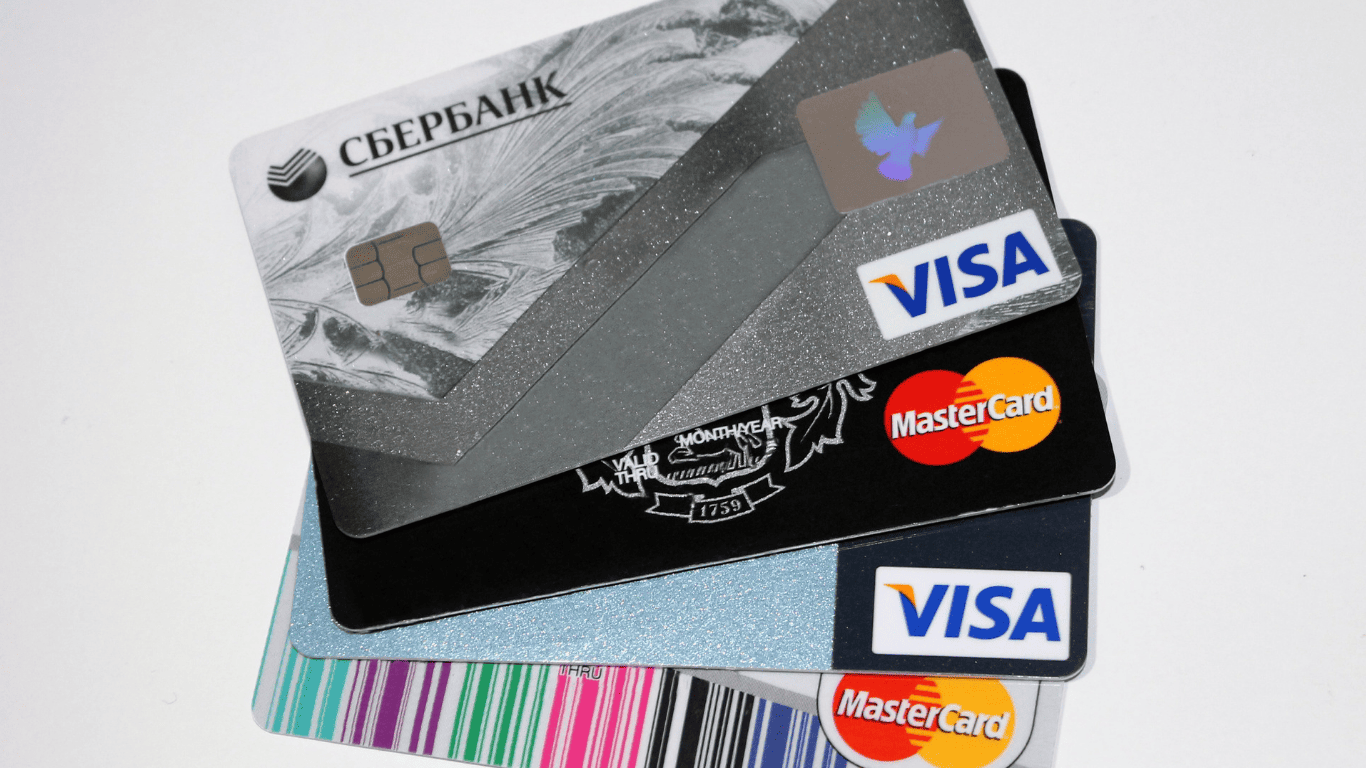 Assorted Visa and Mastercard credit cards stacked together.