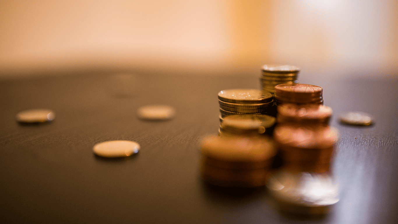 Stacks of coins on a table representing money, savings, and financial growth.