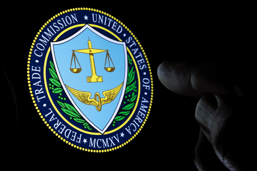 Hand pointing at the Federal Trade Commission (FTC) seal on a screen.
